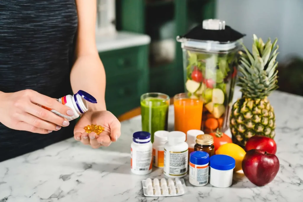 Woman holding vitamin supplements with fresh fruits and juices on table