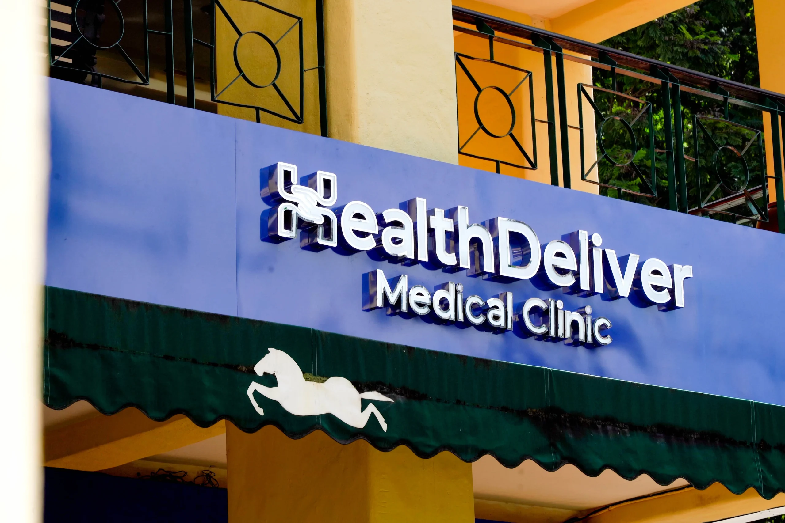 HealthDeliver Medical Clinic storefront sign with horse logo